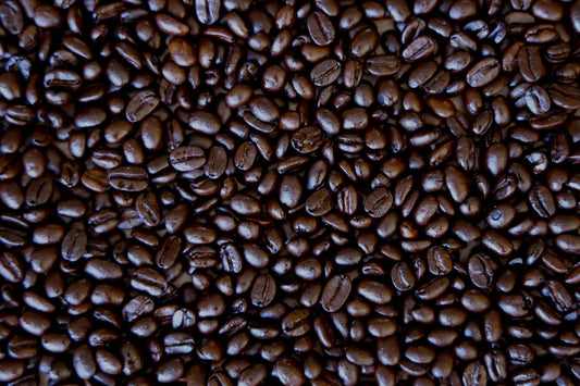 Close-up of fresh oily dark roast coffee beans showing surface sheen from second-crack roasting, small-batch roasted at Aldo's Coffee in Greenport, NY