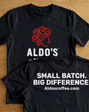 Black t-shirt with red and white graphics and text on a wooden surface